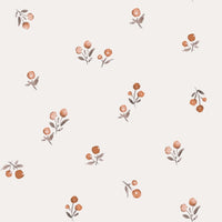 Een vredige pasgeboren baby die slaapt, gekleed in een schattig bedrukt Yumi Baby Broekje Peach Blossom onesie en bijpassend hoedje, liggend op een zacht wit oppervlak met de armen zachtjes omhoog bij het gezicht.