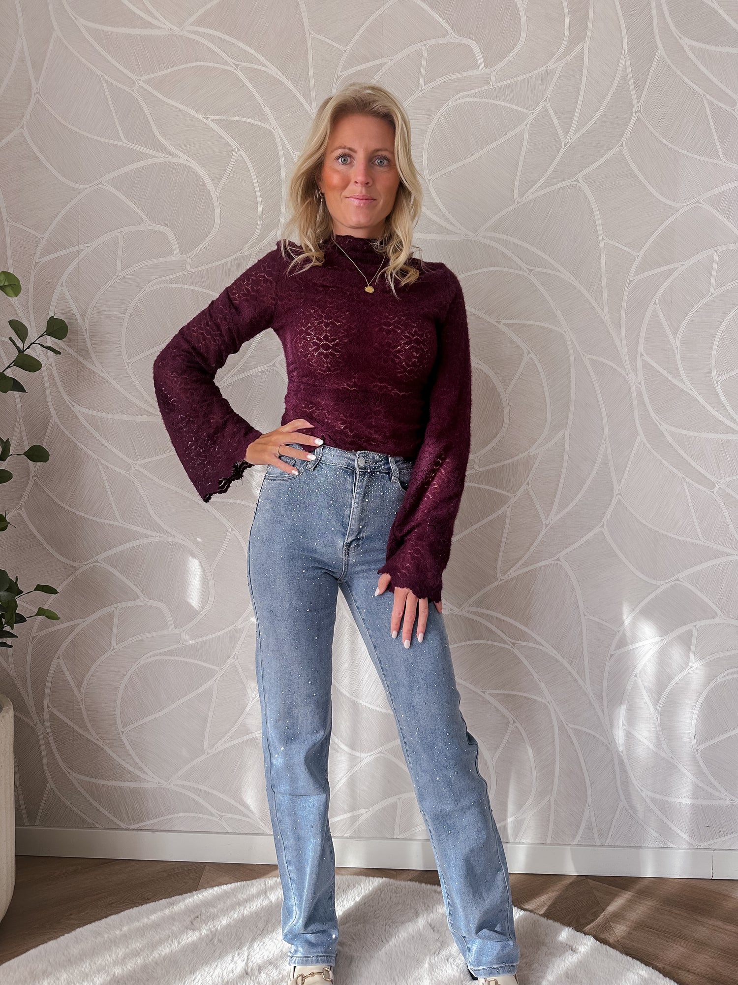Model showr licht blauwe straight jeans met stretch met burgumdy lace top