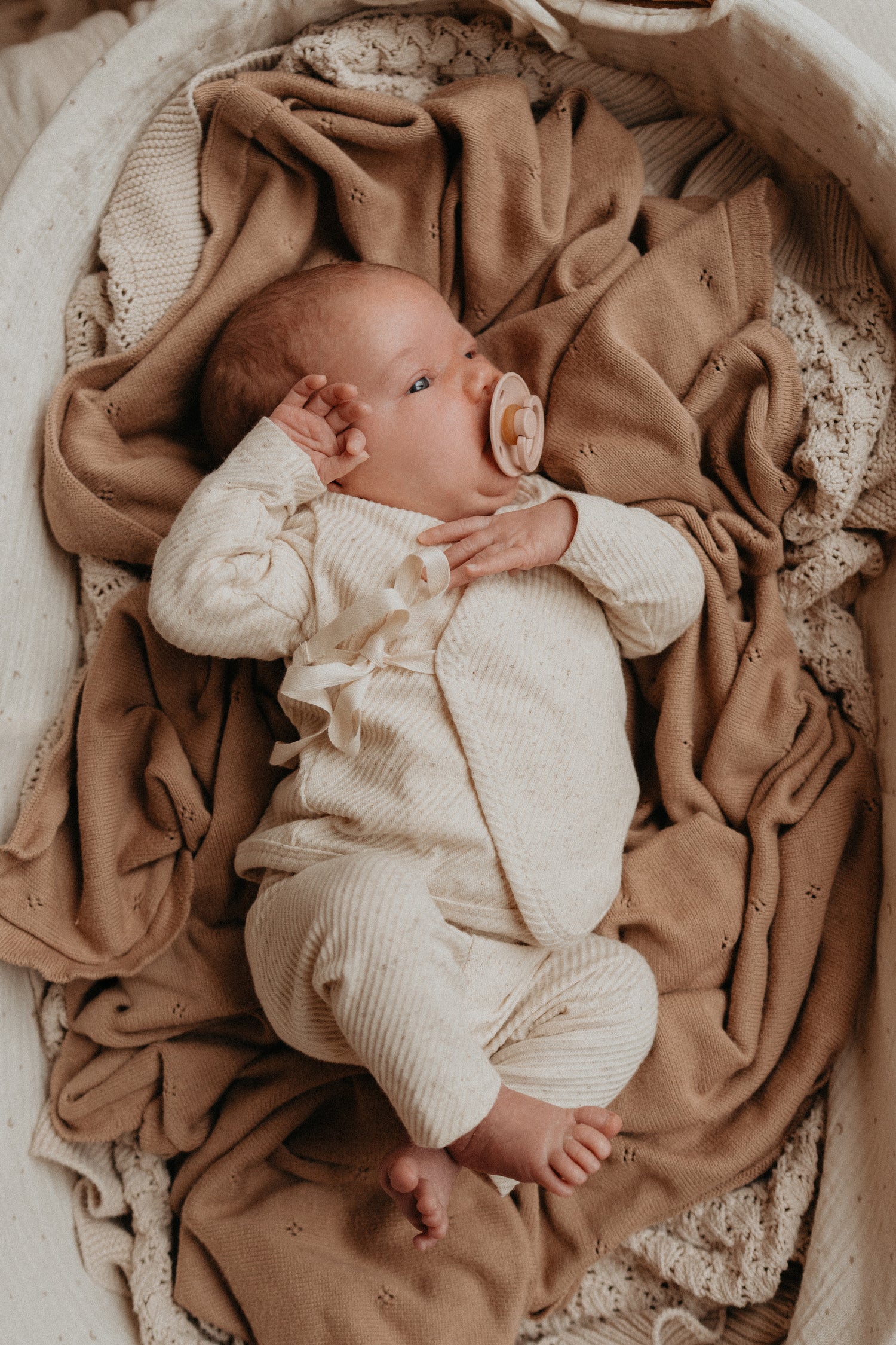 Baby met een neutraal rib jersey broekje en shirtje. het perfecte geboortepakje
