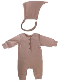 Een stille pasgeboren baby, gekleed in een gezellige bruine onesie met een puntige capuchon en een Yumi Baby Strikmutsje Blush, comfortabel.