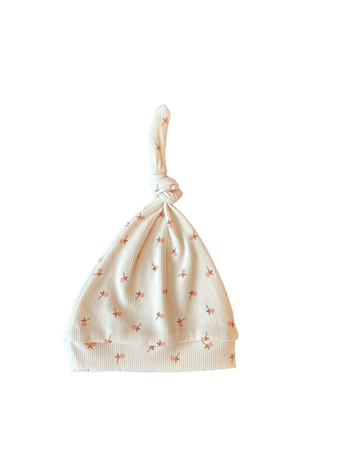 Een gapende baby gekleed in een knus rompertje met een bijpassend pasgeboren Muts Tiny Tulip babymutsje van Yumi Baby, comfortabel genesteld in een geweven mand op een zachte, zijdezachte deken.