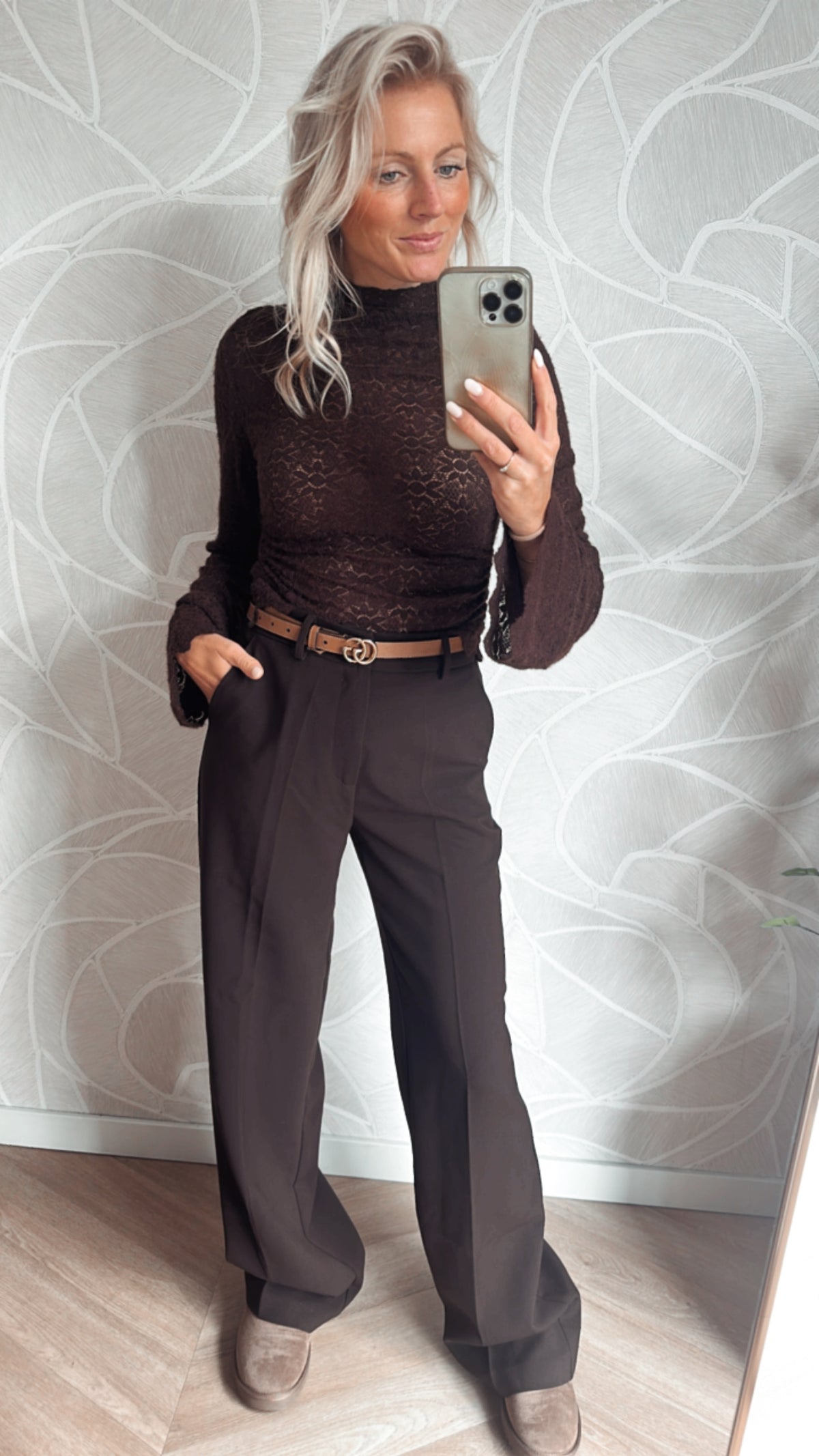 Model showt bruine bloemen lace top met bruine pantalon