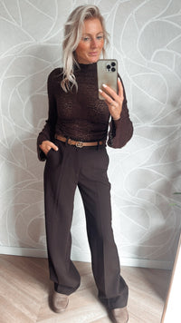 Model showt bruine bloemen lace top met bruine pantalon