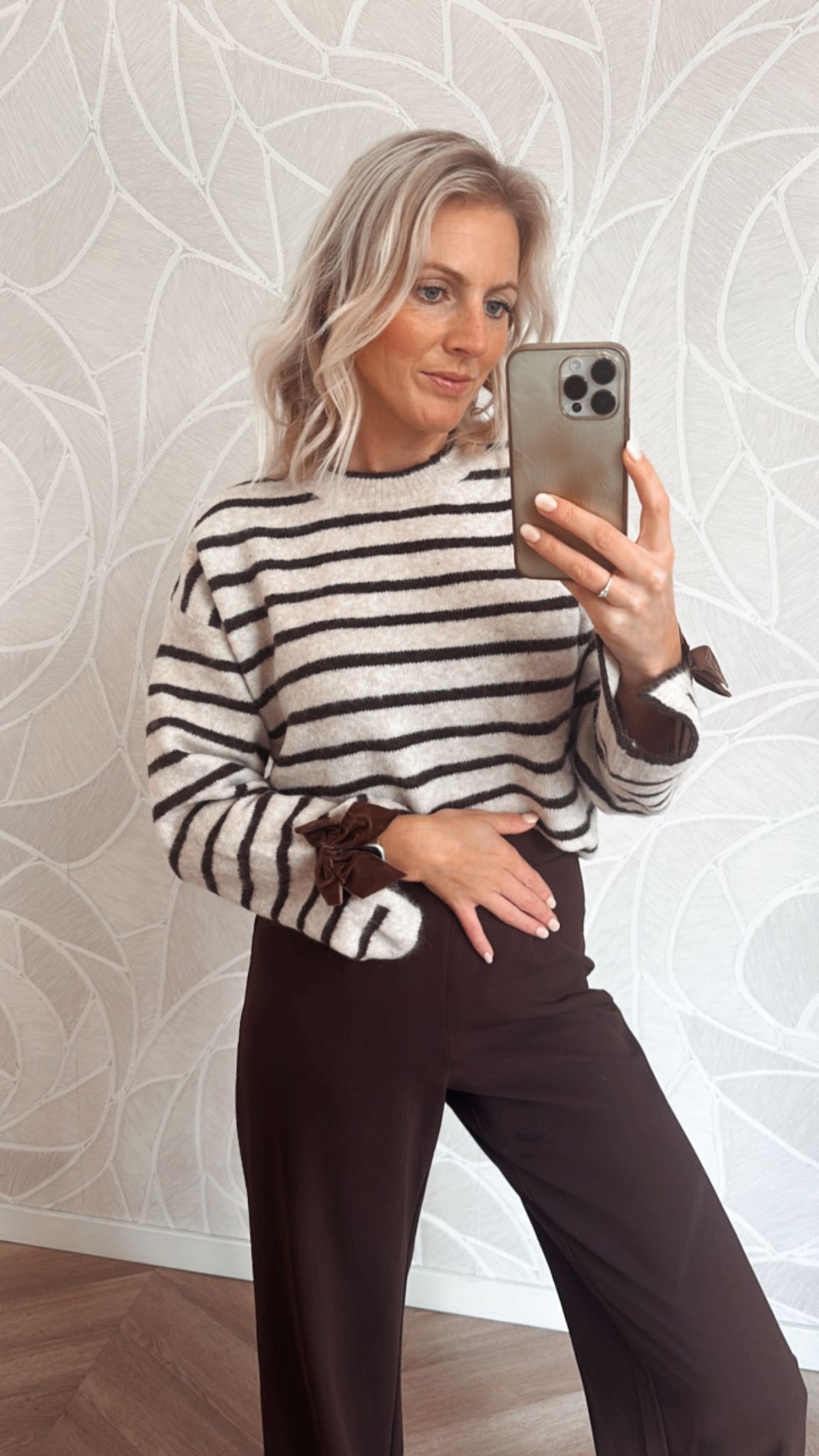 Beige wit gestreepte trui met strik details en een bruine pantalon
