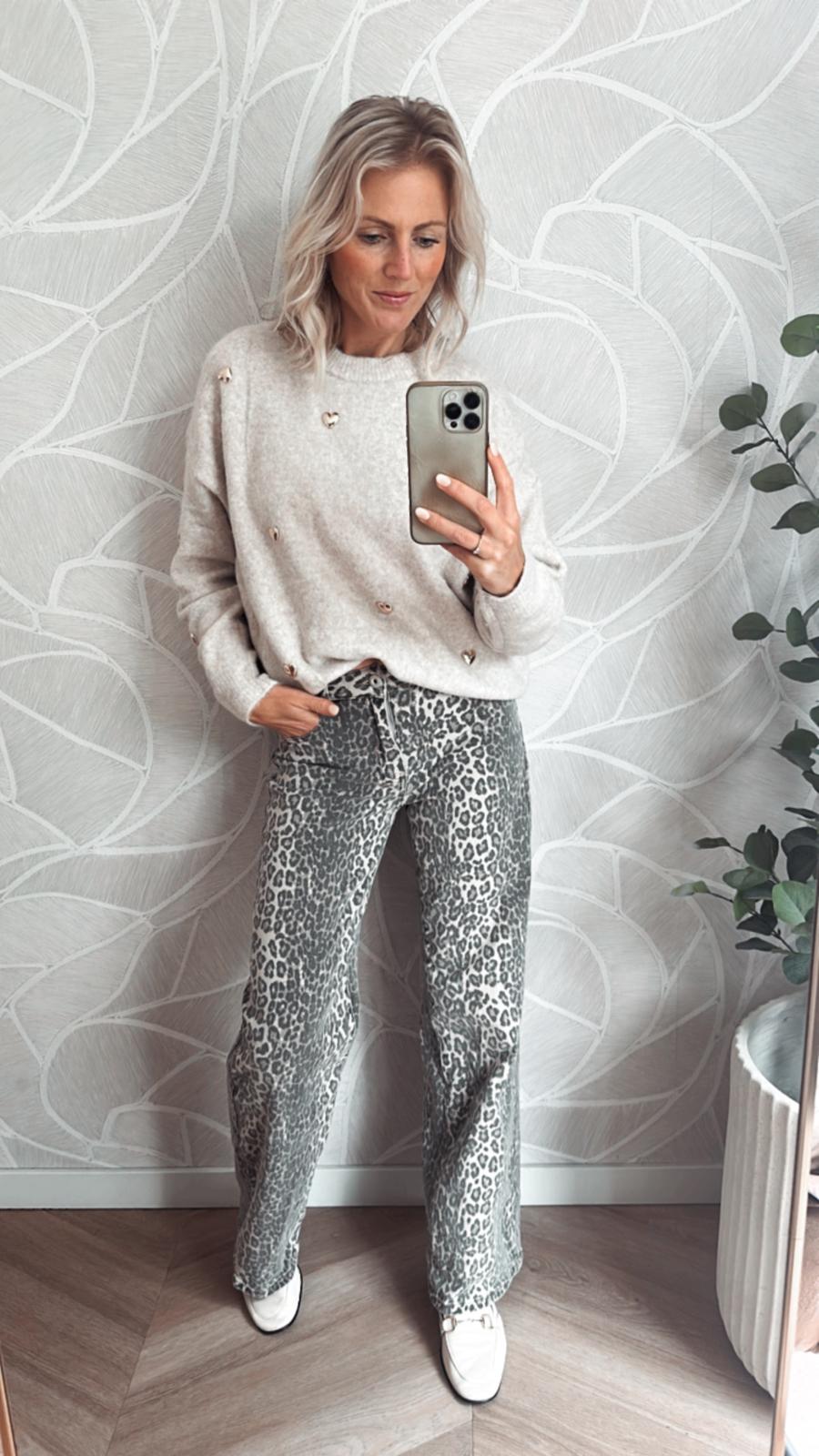 Vrouw draagt een straight fit broek met grijze panterprint, gecombineerd met een beige trui – Yumi Fashion