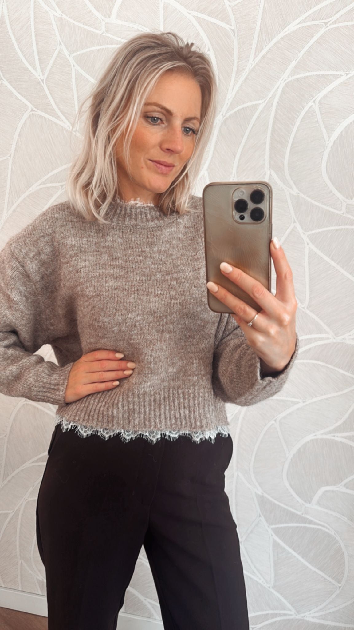 Vrouw draagt taupekleurige trui met rafelrand – zachte knit sweater van Yumi.