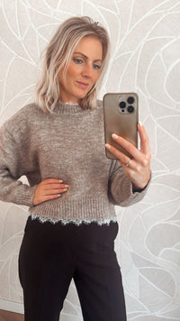 Vrouw draagt taupekleurige trui met rafelrand – zachte knit sweater van Yumi.