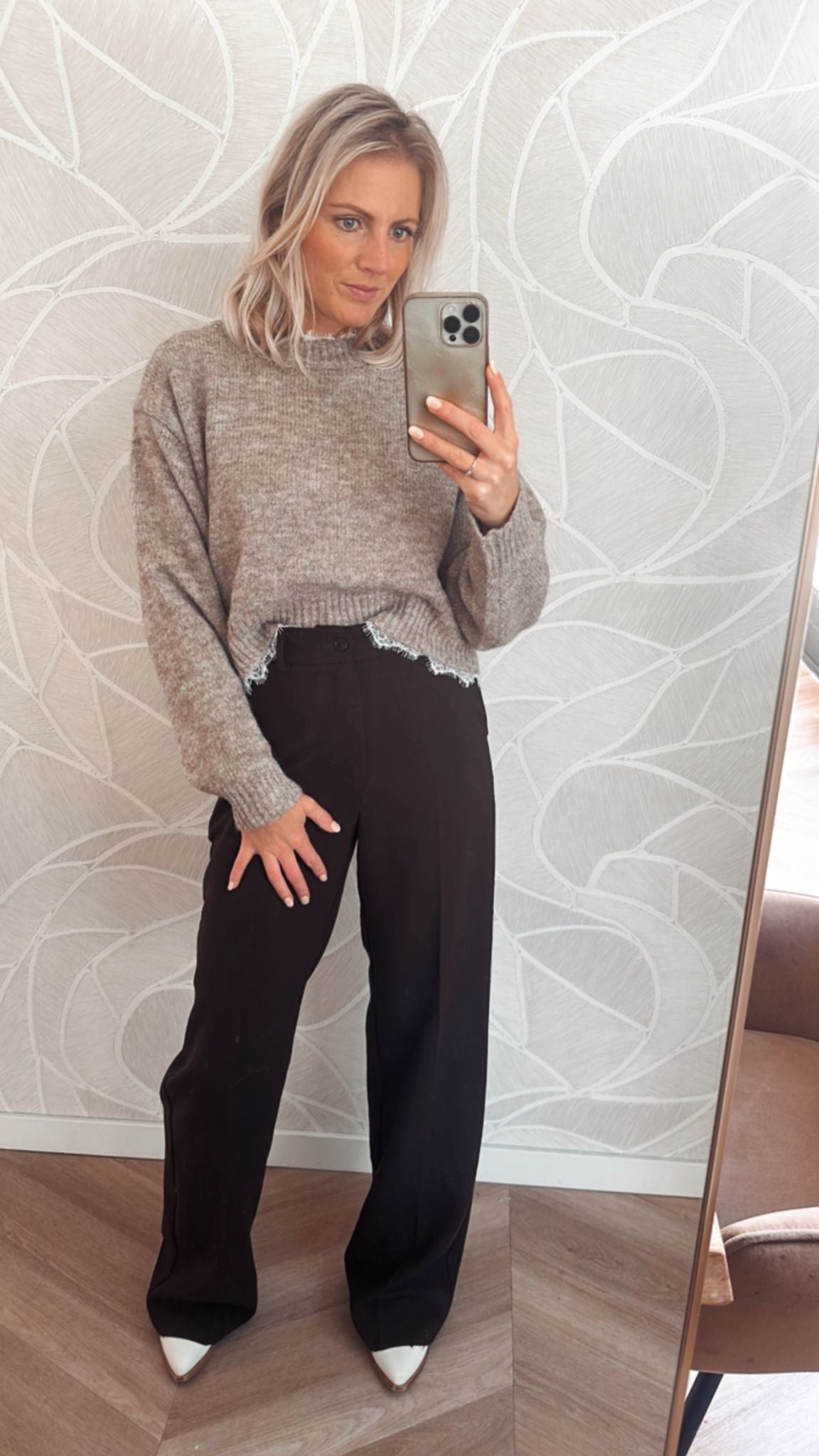 Vrouw draagt taupekleurige trui met rafelrand – zachte knit sweater van Yumi.