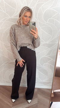 Vrouw draagt taupekleurige trui met rafelrand – zachte knit sweater van Yumi.